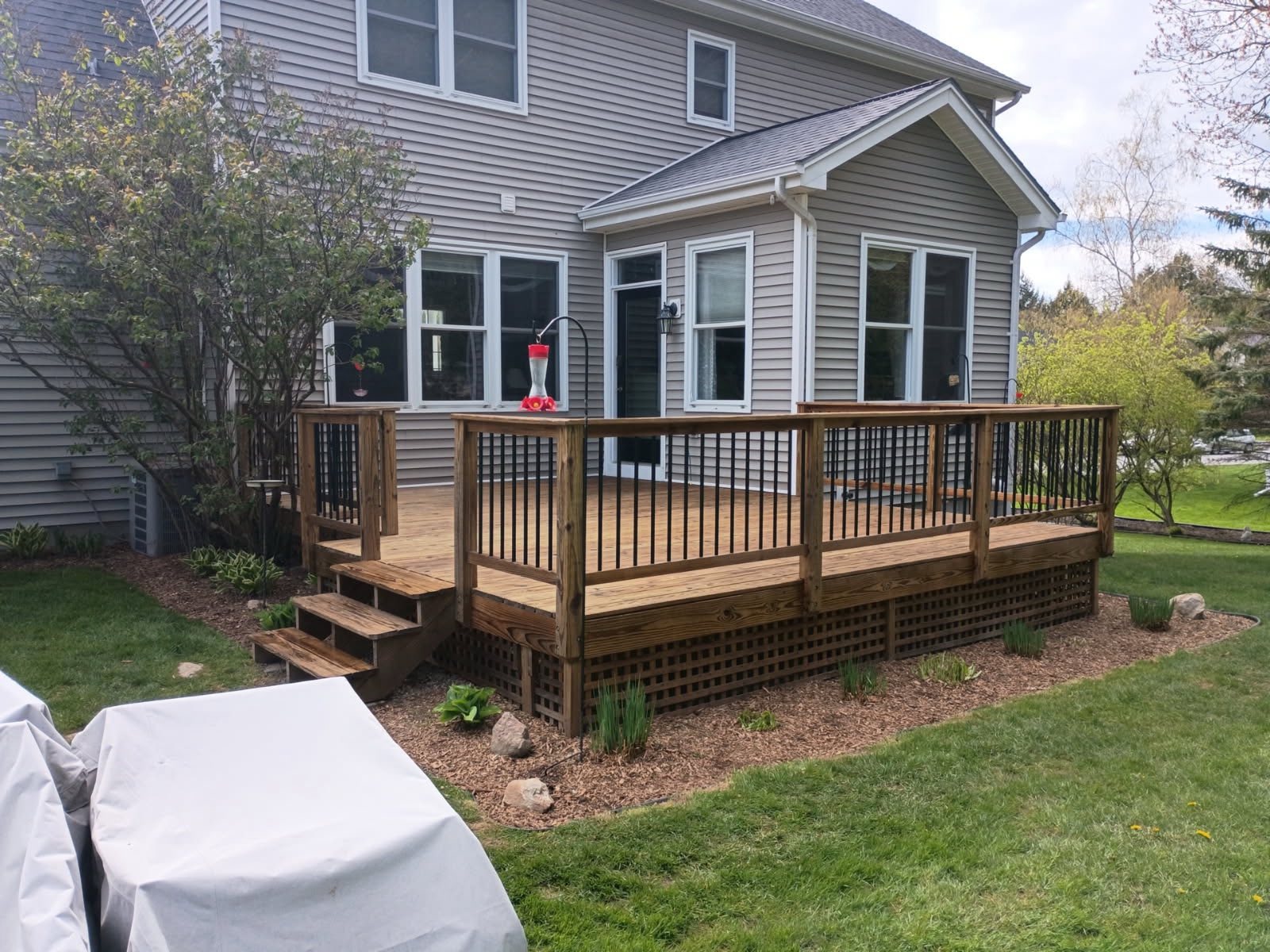 Completed wood deck with black iron balusters and lattice skirt