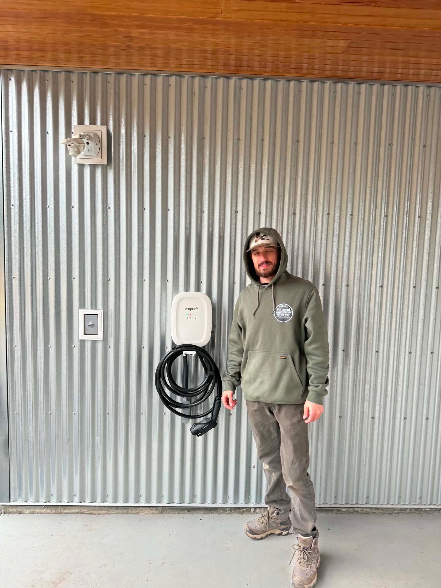 Completed Emporia EV charger mounted — VTGC tech posing