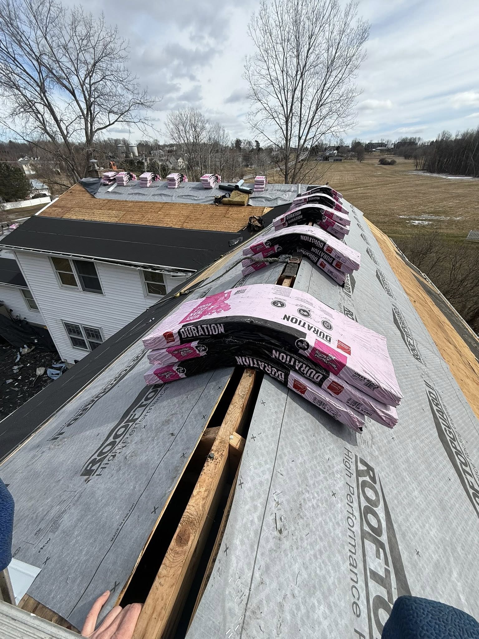 Roof tear-off in progress — exposed decking and old sheathing
